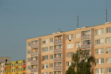 A sizable, multistory apartment building stands tall against a vibrant blue sky, showcasing its...