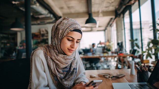 Young Woman Wearing Hijab Using Smartphone in Modern Cafe