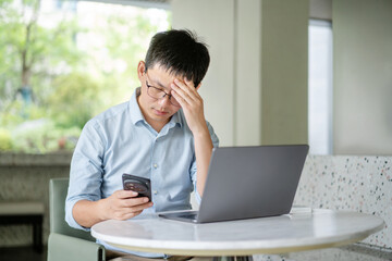 asian businessman working on laptop and smart phone