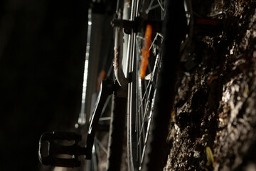 A detailed close up of a bicycle wheel, showcasing its intricate design, captured in a dimly lit...
