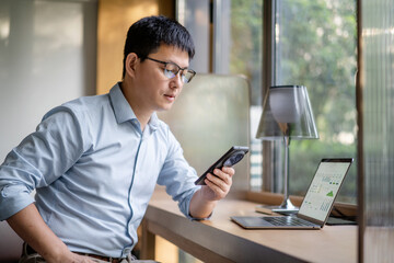 asian businessman working on laptop and smart phone