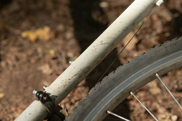 This image depicts a closeup view of a bicycle that features a tire resting on the ground, showcasing its intricate details and components