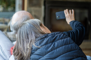 Rear View of Senior Couple Taking Selfie on Couch