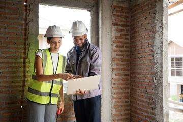 Two Engineer builder. Foreman use notebook computer and walkie talkie working in construction site.	