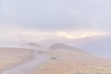 The path down from the summit of Fairfield, looking towards Great Rigg and Heron Pike on a misty day, Fairfield Horseshoe, Lake District, UK