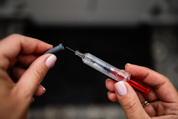 Nurse preparing syringe with needle for injection