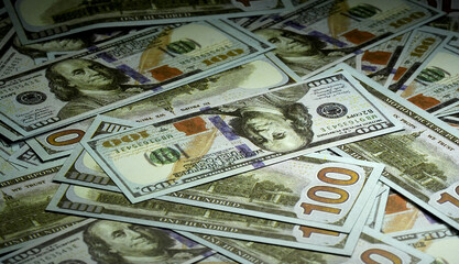 A bunch of 100-dollar bills scattered on table