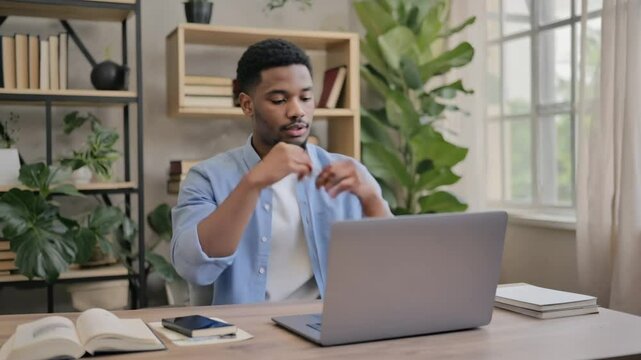 Young Man Working on Laptop from Home Office
