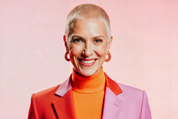 A striking portrait of a smiling woman with short, light-colored hair and bright, contrasting clothing
