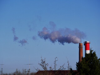 A red and white tower with smoke coming out of it