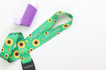 Hidden disability lanyard with a asthma device in a light background
