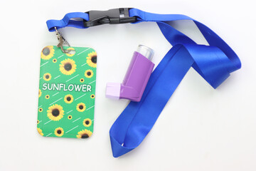 Hidden disability lanyard with a asthma device in a light background