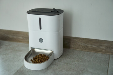 A contemporary automatic pet feeder featuring a chic design and a highly functional kibble...