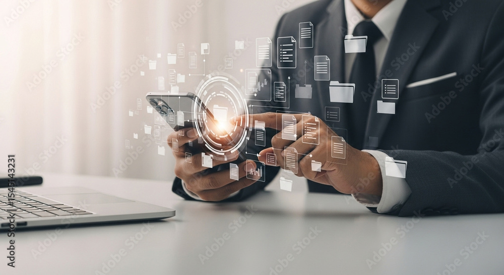 Poster Businessman using smartphone with digital file management system and laptop on the table at the office