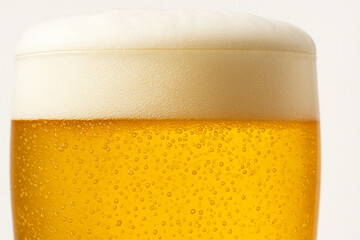 Close-up of a glass of golden beer with refreshing bubbles and a thick white foam head, isolated on a white background, perfect for beverage or bar themes.