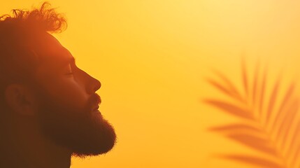 Silhouette of Bearded Man with Palm Leaf Against Golden Sunlight and Sky