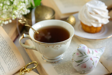 A cup of tea and a bouquet of lilies of the valley, books on a spring morning.