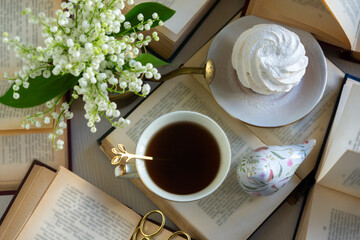 A cup of tea and a bouquet of lilies of the valley, books on a spring morning.