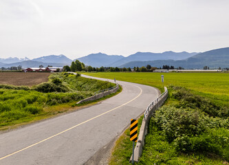 Scenic Country Road in Chilliwack, BC Surrounded by Green Fields and Mountains