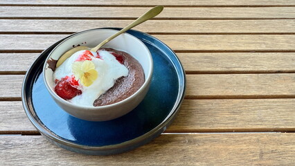 Chocolate fondant dessert with vanilla ice cream, strawberry sauce and edible flower