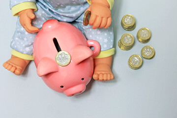 piggy bank and baby doll adding money