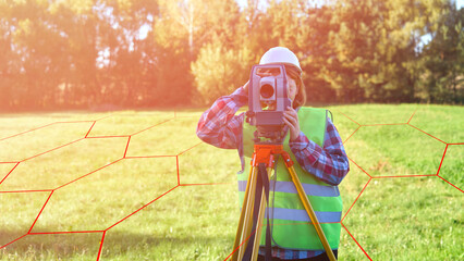 A man in a vest is standing in a field with a surveying instrument. The image has a sense of...