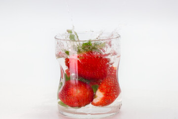 Fresh strawberries splashing in water creating a refreshing drink experience during a summer day