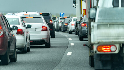 A busy highway with a truck in the middle of the traffic. Scene is chaotic and stressful