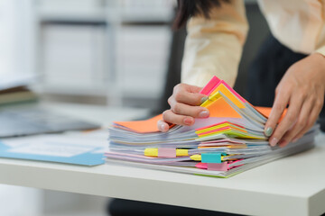 Woman Organizing Colorful Documents on Desk