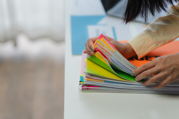 Woman Organizing Colorful Documents on Desk
