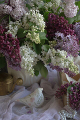 A bouquet of lilacs on the table and a cup of tea.