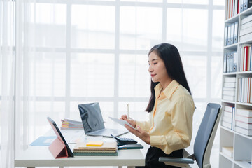 Asian Woman Working at Desk in Bright Office