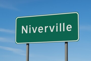 Green roadside sign reading "Niverville" in white letters, set against a bright blue sky with thin clouds, marking town entry.