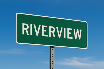 Green roadside sign with "Riverview" in bold white letters, standing under a clear blue sky, indicating town entry.