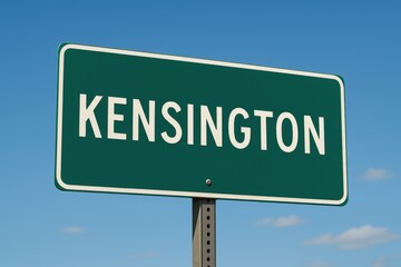 Green road sign displaying "KENSINGTON" under a bright blue sky, indicating town entrance, travel route, or Prince Edward Island location.