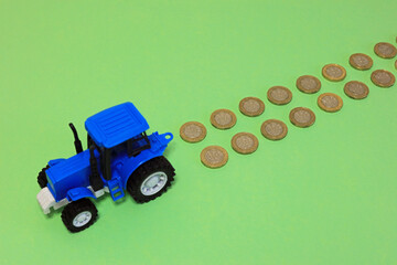 toy tractor and money. farming profits concept.