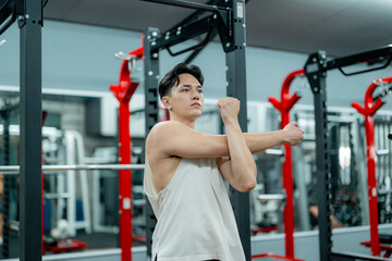 Young Sportsman Stretching Arms at the Gym Before Training