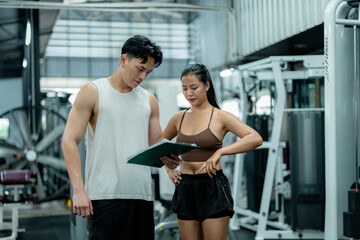 Personal trainer showing results to woman in gym