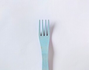 Blue plastic fork on white background 