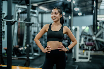 Young sportswoman posing in the gym with hands on hips