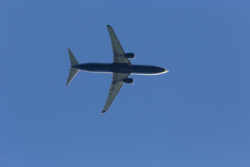 A commercial airplane flying in the clear blue sky, down up still image