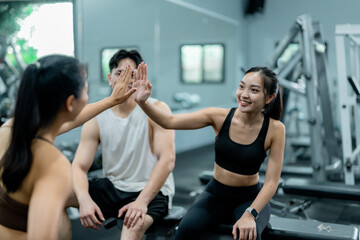 Group of young athletes giving high five after training in gym