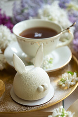 Spring on the table, Easter sweets in the form of rabbits and a porcelain cup, tea or coffee.