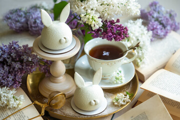 Spring on the table, Easter sweets in the form of rabbits and a porcelain cup, tea or coffee.