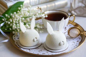 Spring on the table, Easter sweets in the form of rabbits and a porcelain cup, tea or coffee.