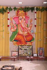 simple Hindu stage décor with Lord Ganesha as the backdrop in a golden theme