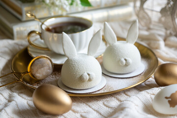 Spring on the table, Easter sweets in the form of rabbits and a porcelain cup, tea or coffee.