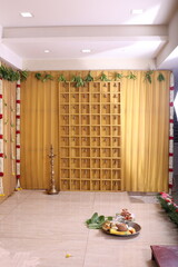 simple Hindu stage décor with Lord Ganesha as the backdrop in a golden theme