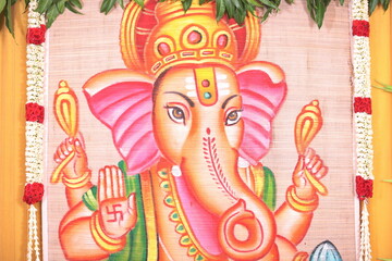 simple Hindu stage décor with Lord Ganesha as the backdrop in a golden theme
