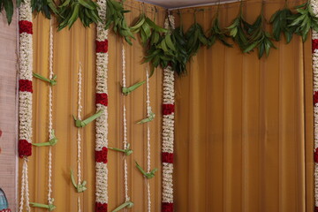 simple Hindu stage décor with Lord Ganesha as the backdrop in a golden theme